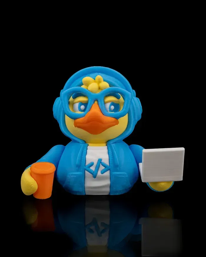 A rubber duck wearing headphones and glasses is holding a cup and a laptop.