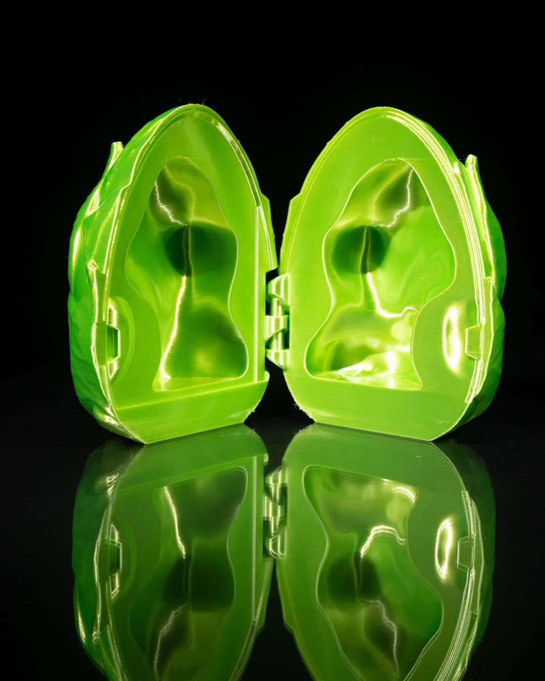 A small figurine of a dragon is sitting next to a green egg.