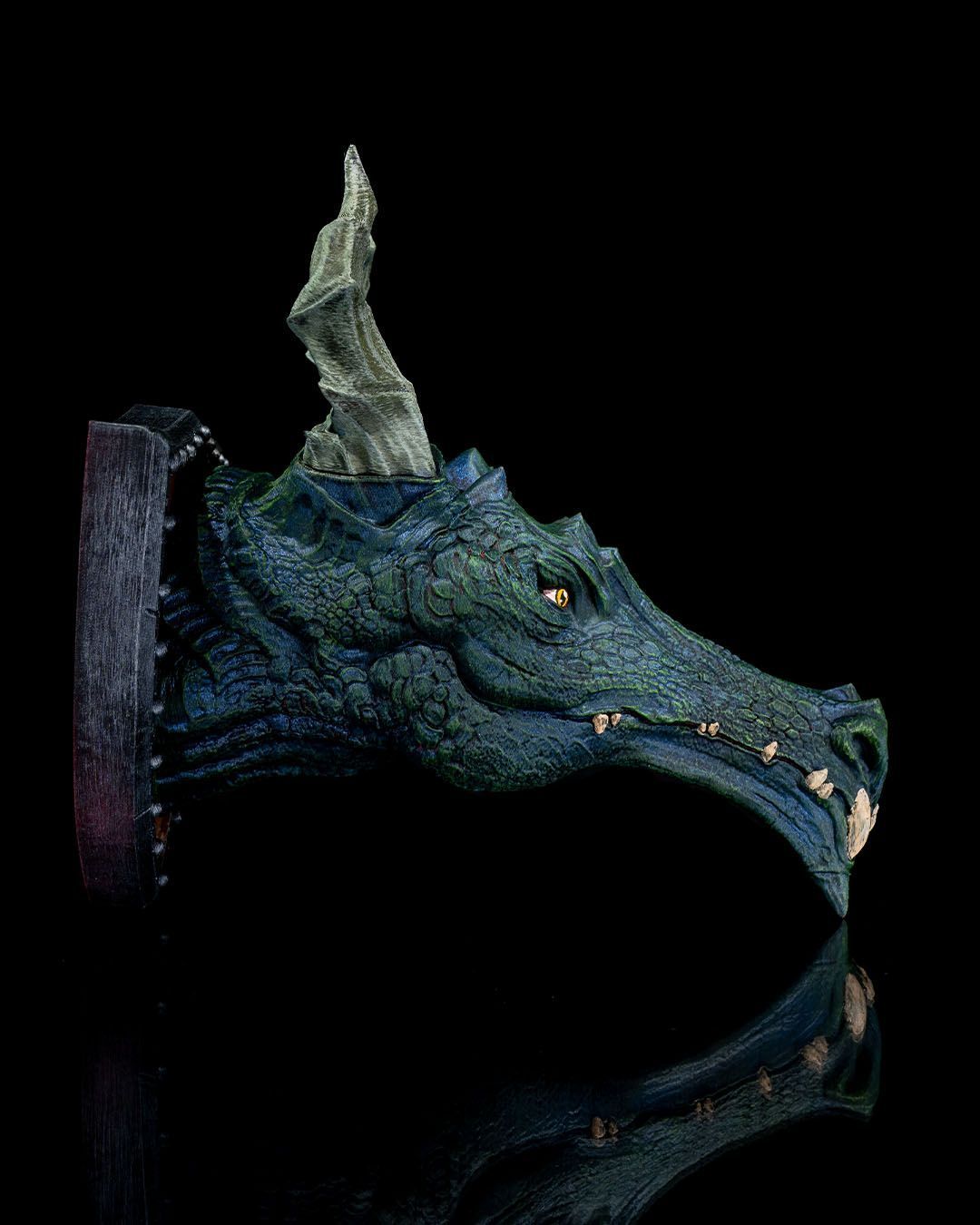 A close up of a dragon 's head with horns on a black background.