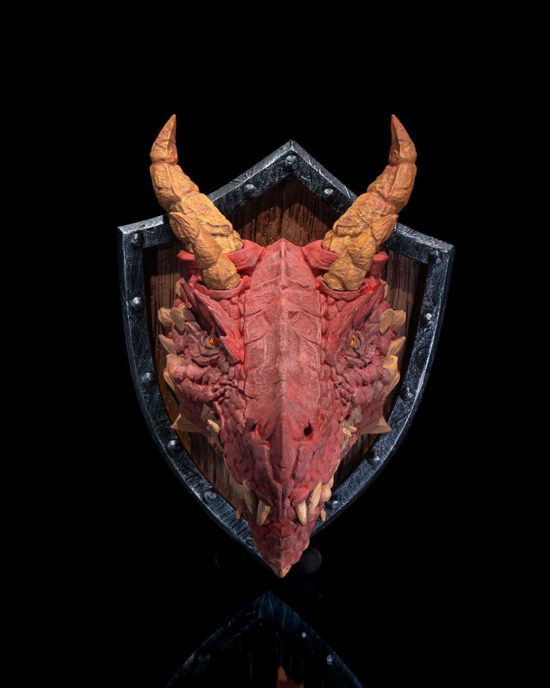 A dragon 's head is mounted on a wooden shield.