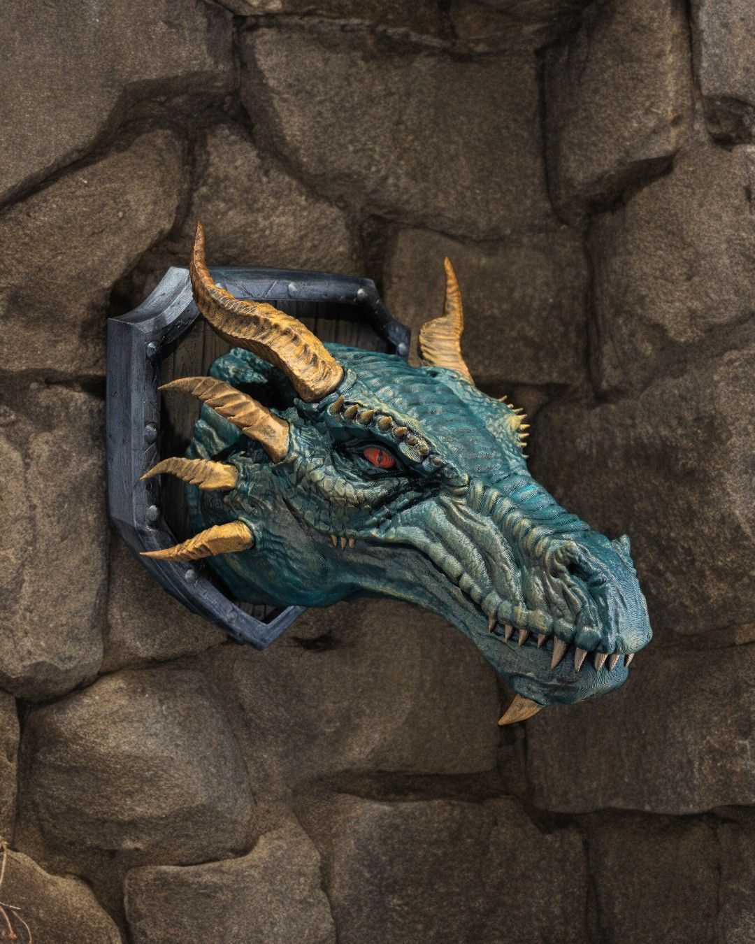 A dragon head with horns is hanging on a stone wall.