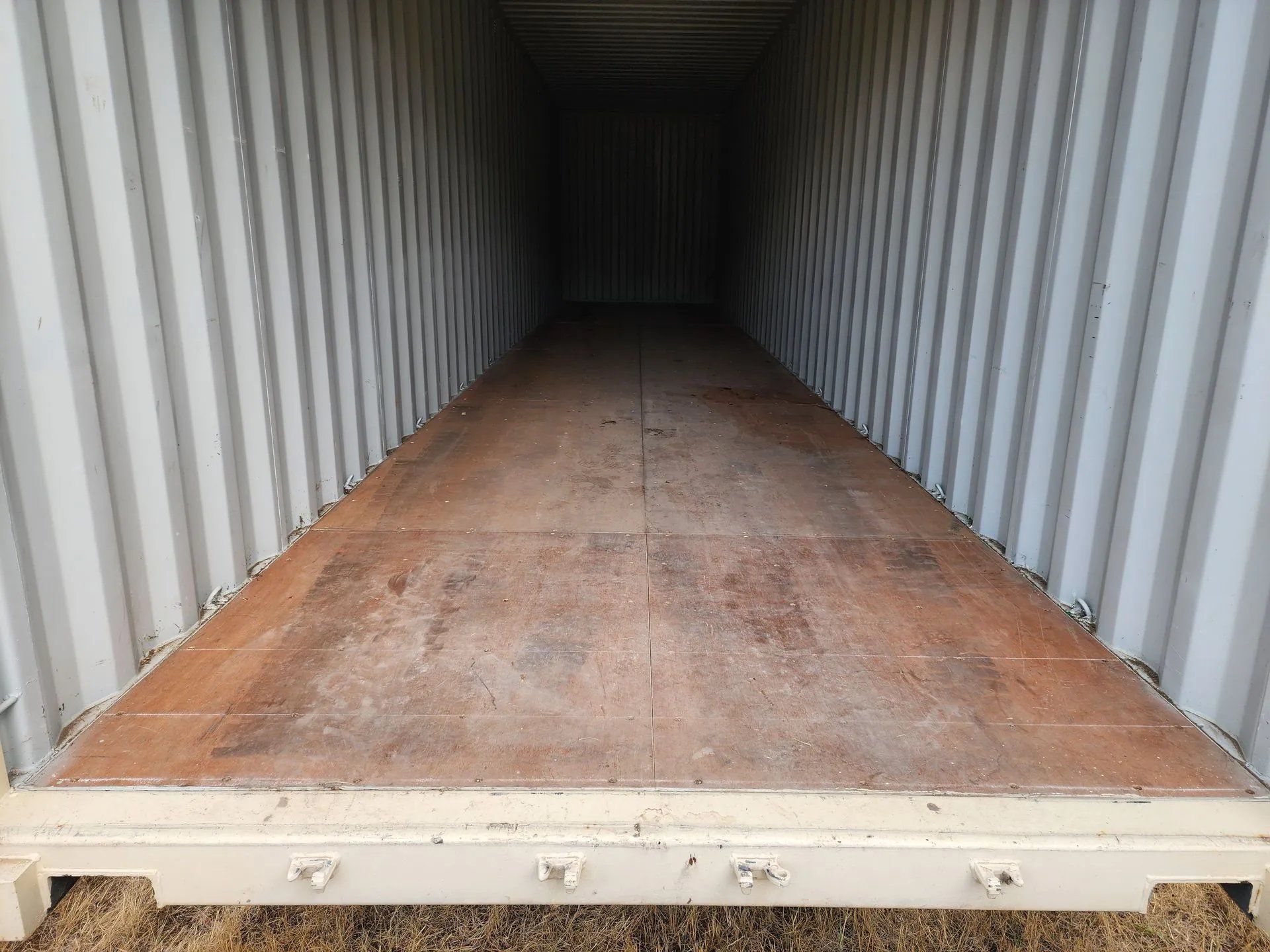 Inside a shipping container, showing the floor, walls, and depth.
