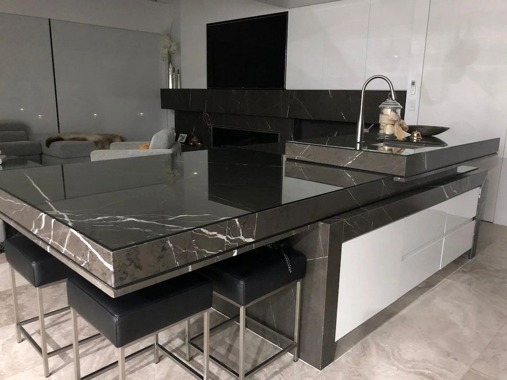 A Kitchen With A Black Marble Countertop And Black Stools — United Kitchens and Joinery in Oak Flats, NSW