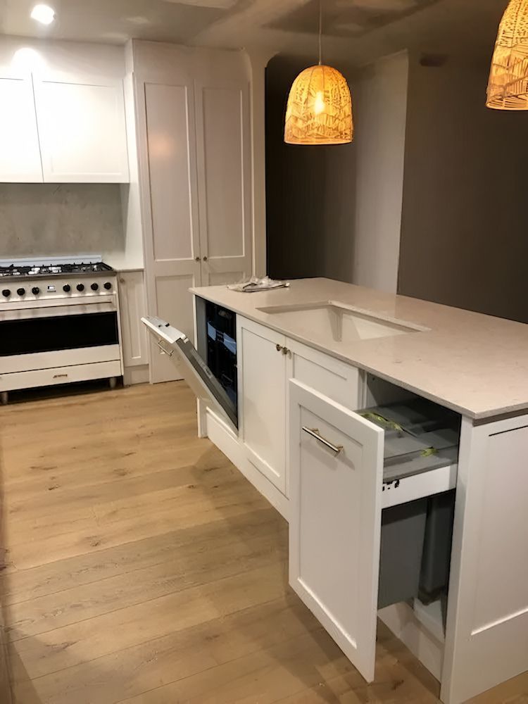 A Kitchen With White Cabinets, A Sink, And A Stove — United Kitchens and Joinery in Thirroul, NSW