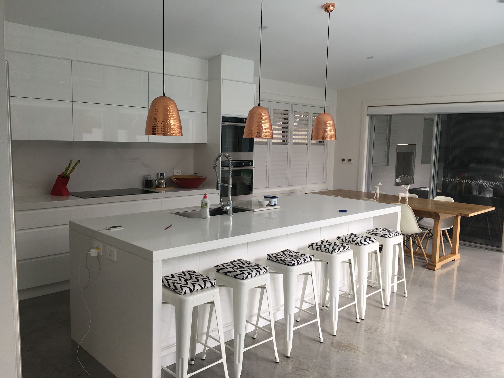 A Kitchen With White Cabinets And A Black Tile Floor — United Kitchens and Joinery in Oak Flats, NSW