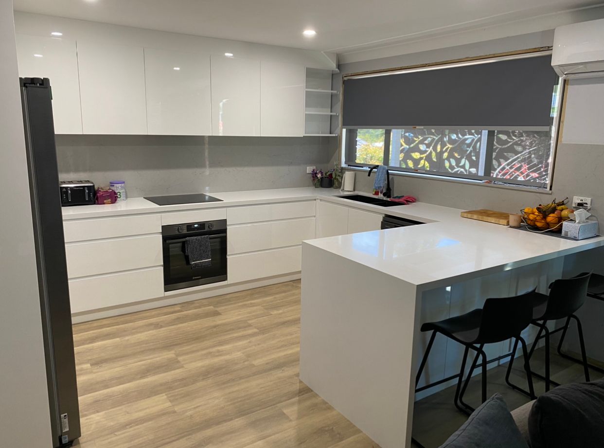 A Kitchen With White Cabinets And Copper Pendant Lights — United Kitchens and Joinery in Vincentia, NSW
