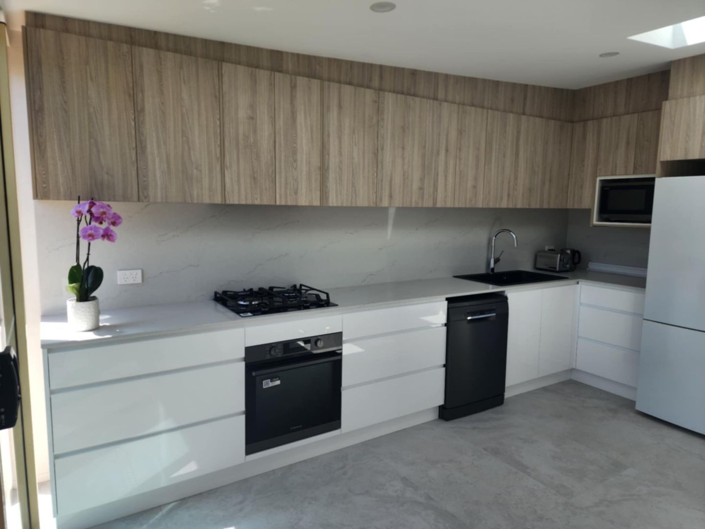 A Kitchen With Hardwood Floors, Stainless Steel Appliances — United Kitchens and Joinery in Oak Flats, NSW