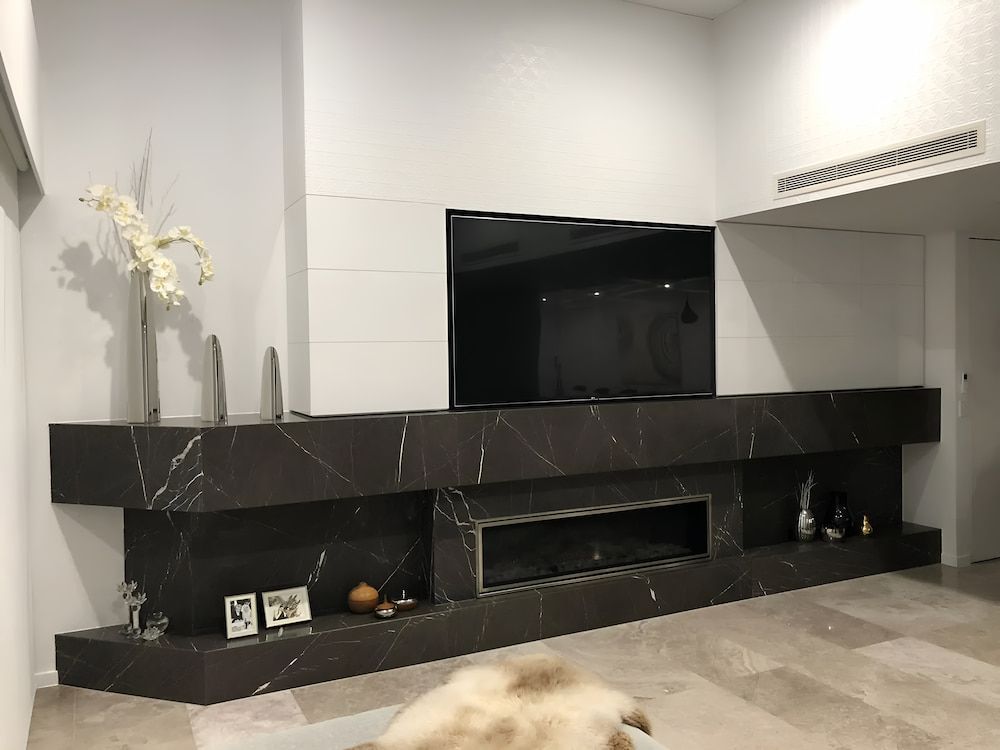 A Living Room With A Fireplace And A Flat Screen Tv — United Kitchens and Joinery in Oak Flats, NSW