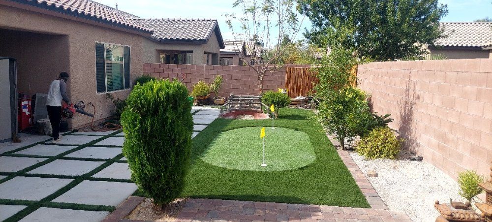 There is a putting green in the backyard of a house.