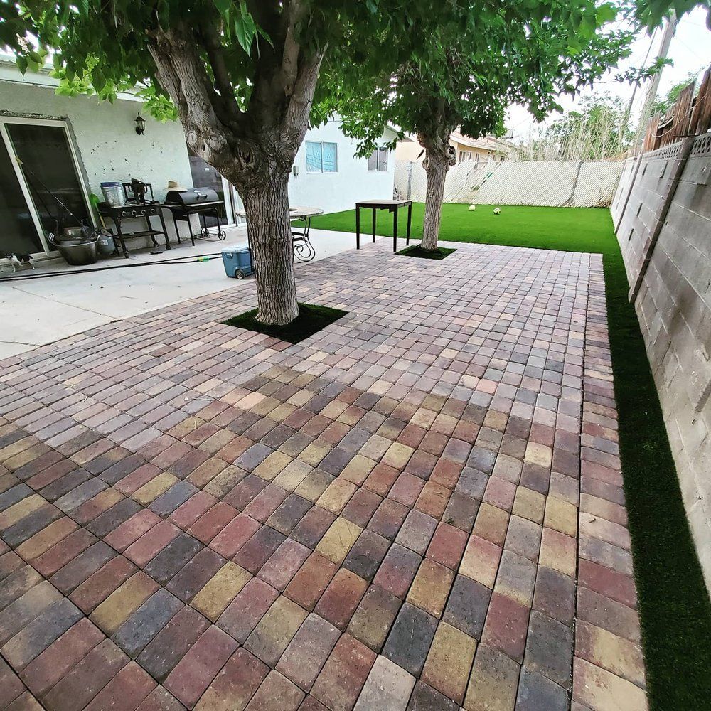 A brick patio with a tree in the middle of it