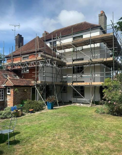 large house with scaffold with  a garden
