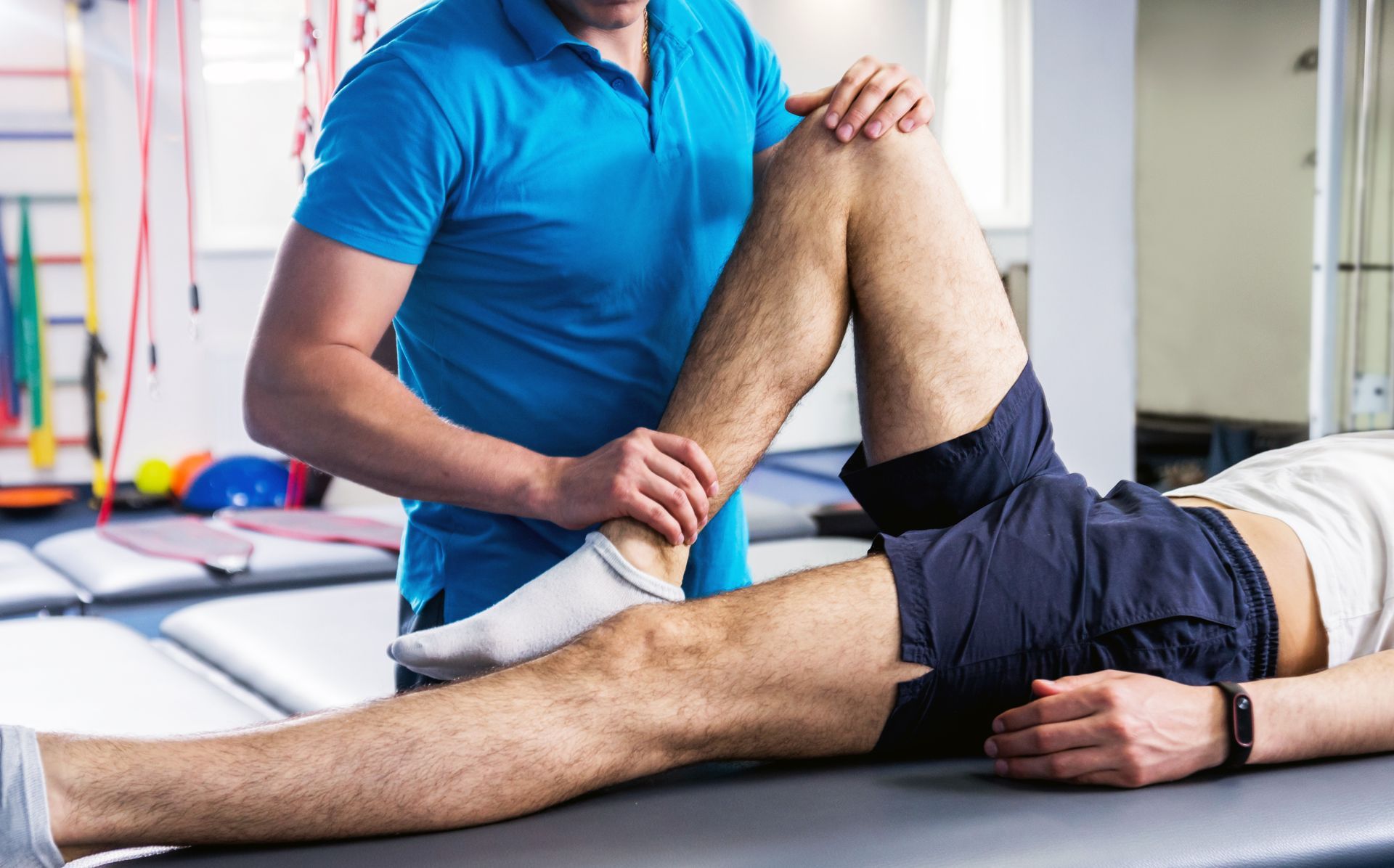 Un homme reçoit un massage du genou par un physiothérapeute.