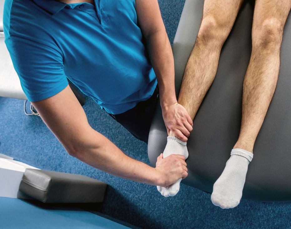 Un homme reçoit un massage du genou par un physiothérapeute.