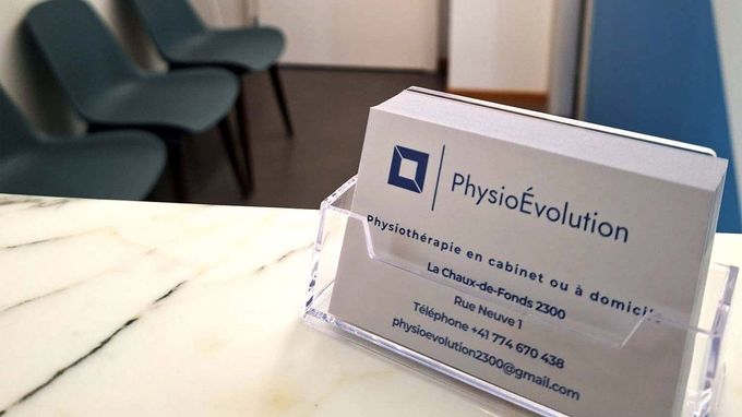 Une carte de visite pour physio evolution est posée sur un comptoir