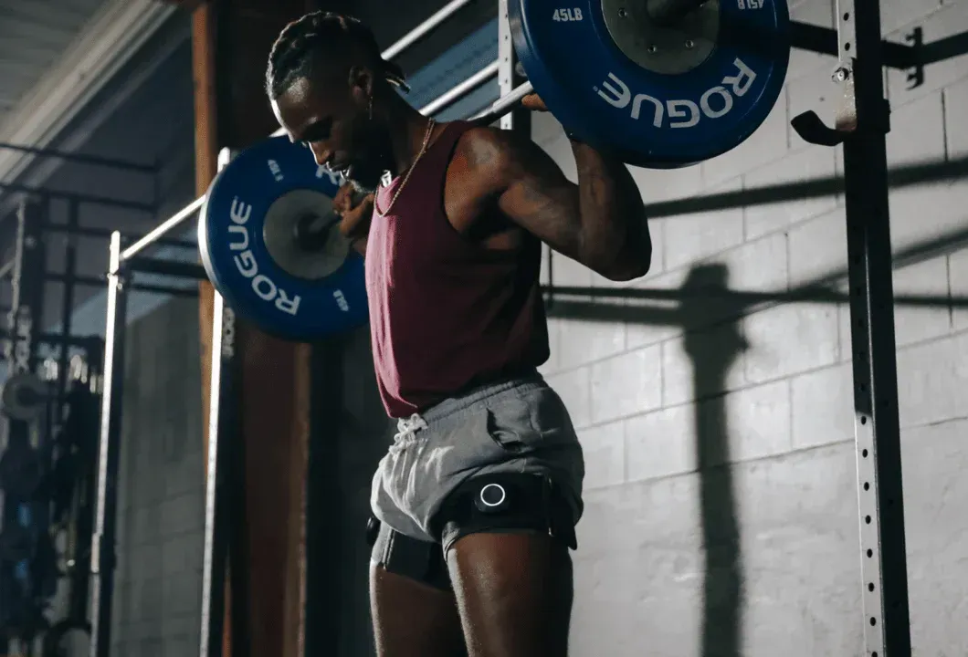 Une femme est debout avec un appareil sur sa cuisse.