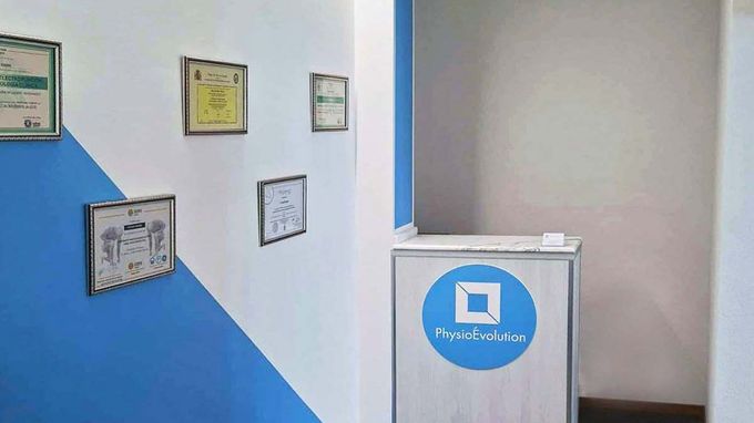 Un couloir avec des murs bleus et blancs et un bureau blanc avec un cercle bleu dessus.