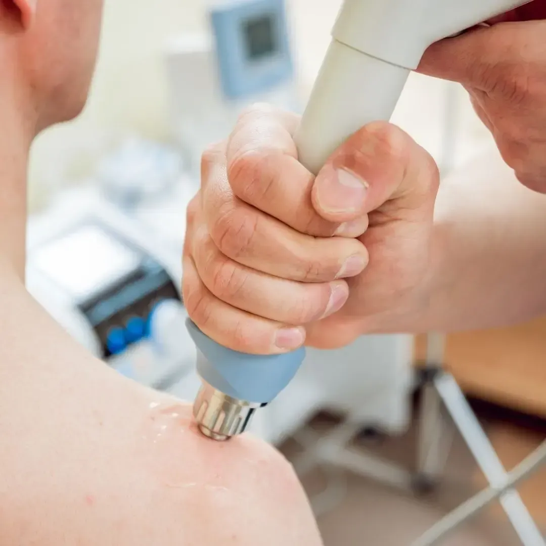 Un homme reçoit une injection sur son épaule avec une machine.