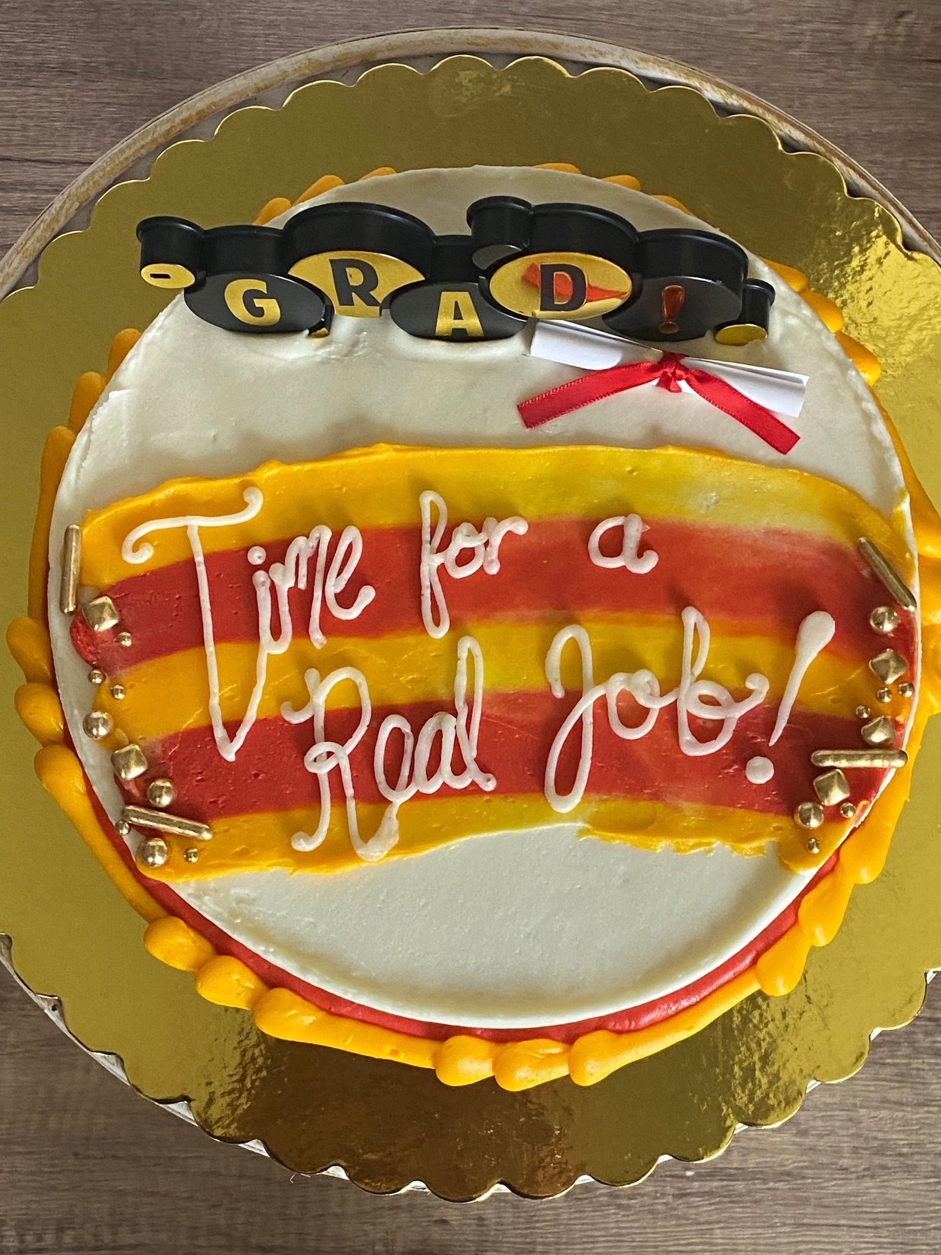 A graduation cake that says time for a real job on it