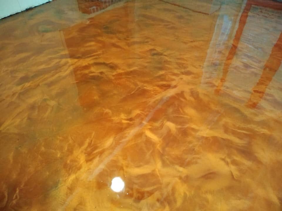 Metallic orange epoxy floor with swirling patterns.