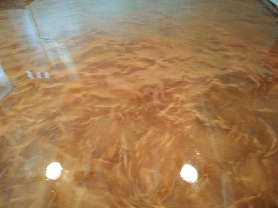 Shiny, amber-colored epoxy floor with swirling patterns and glossy reflections.