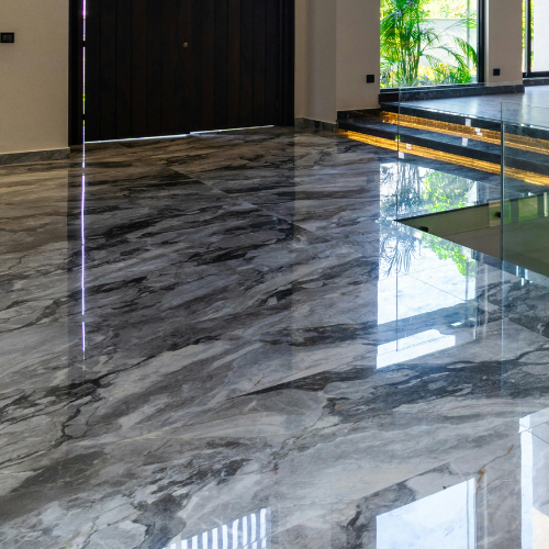 Shiny, marble-patterned gray floor reflecting light in a modern building.