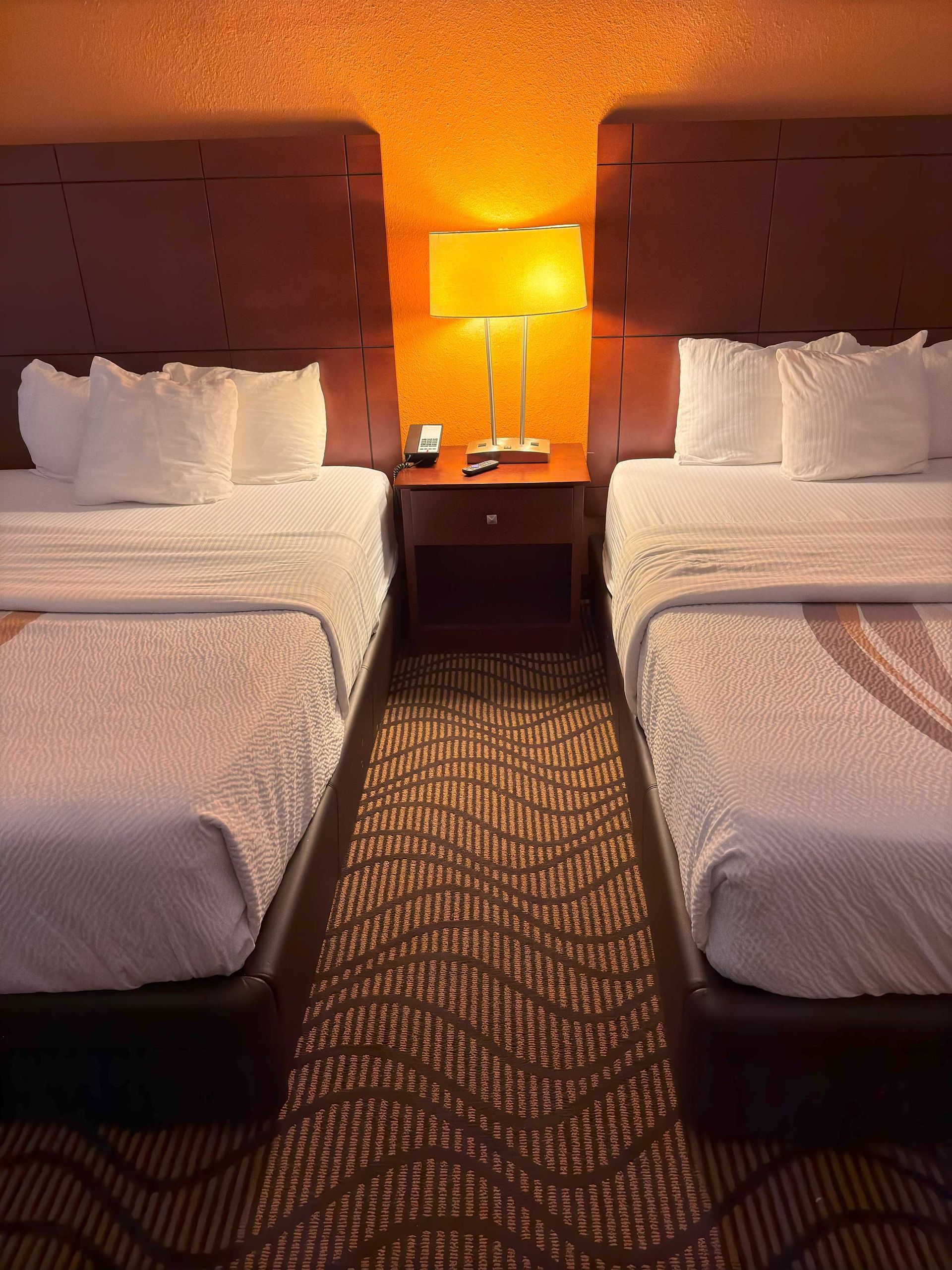 A hotel room with a spiral staircase and a couch.