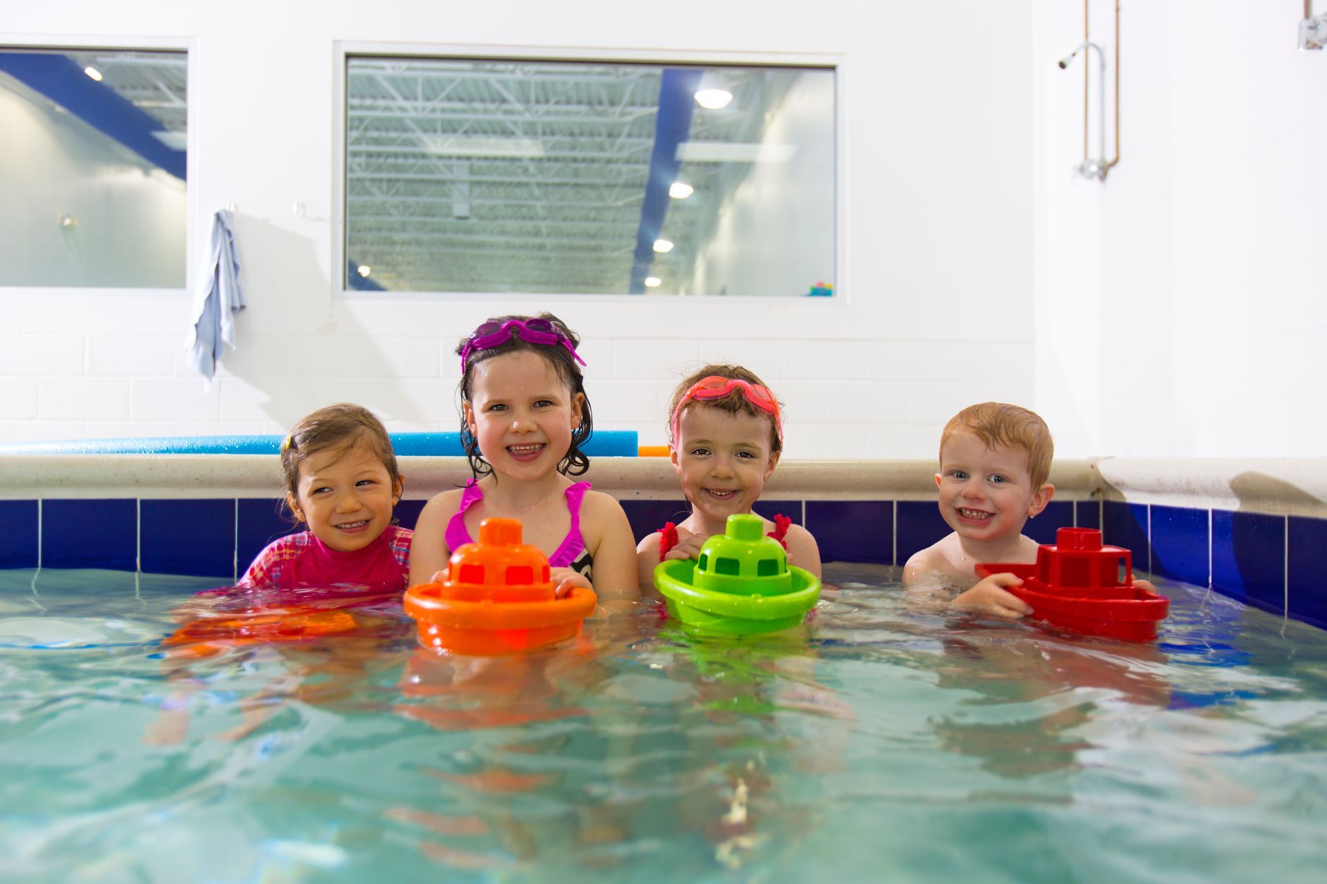 A man is teaching a baby how to swim in a swimming pool.