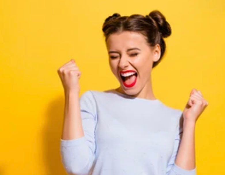 A woman is celebrating her victory with her fists in the air.