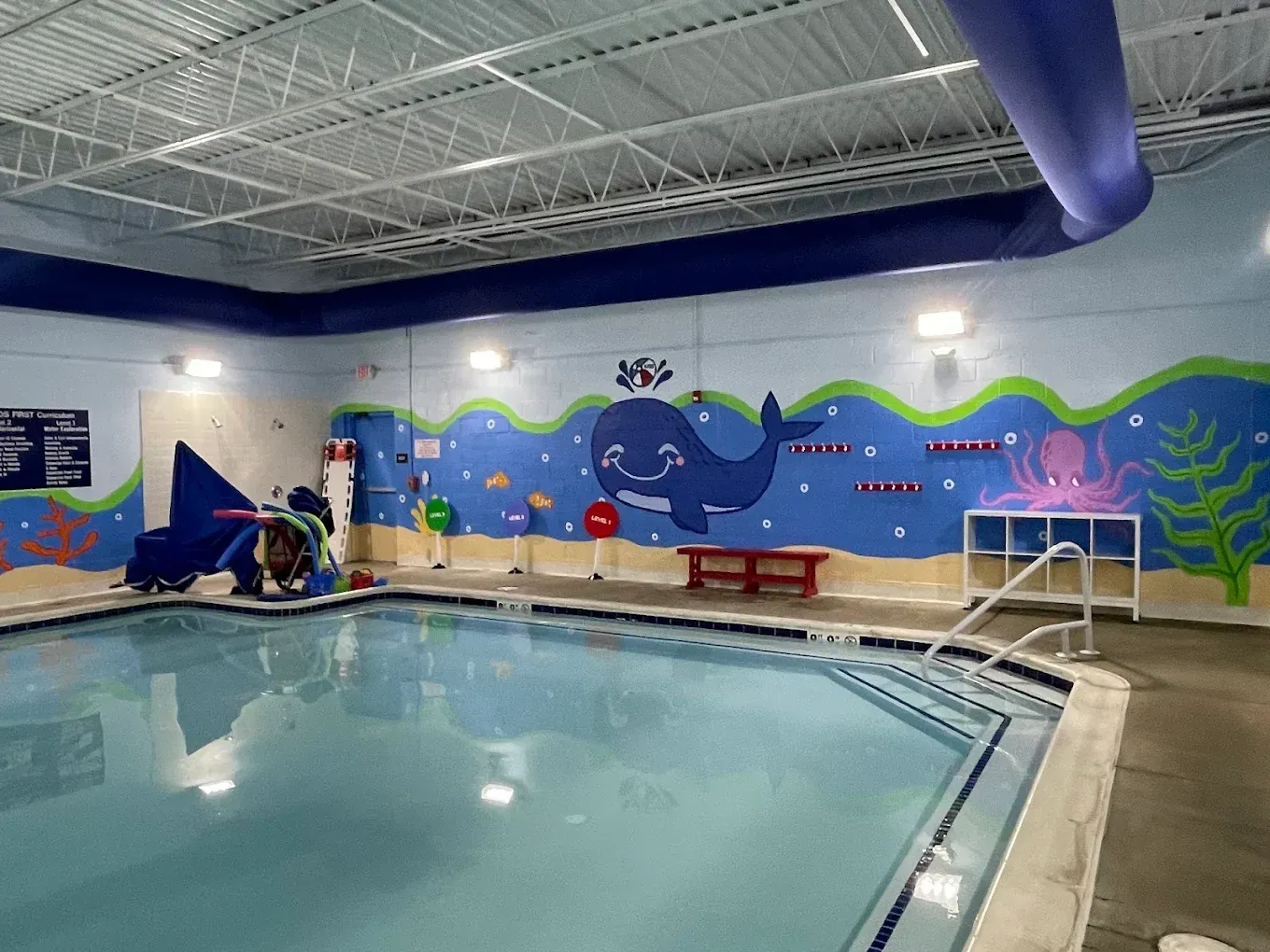 A young boy is swimming underwater in a swimming pool.