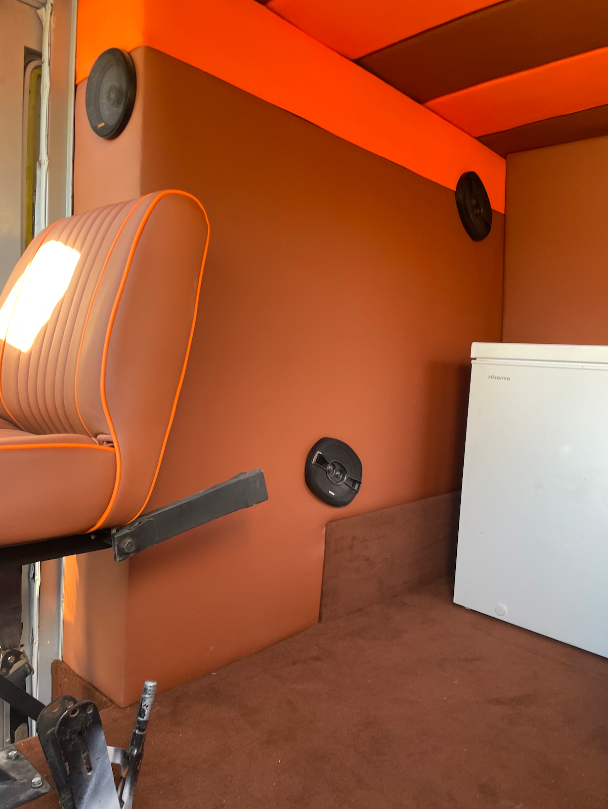 A brown chair is in a room with orange walls