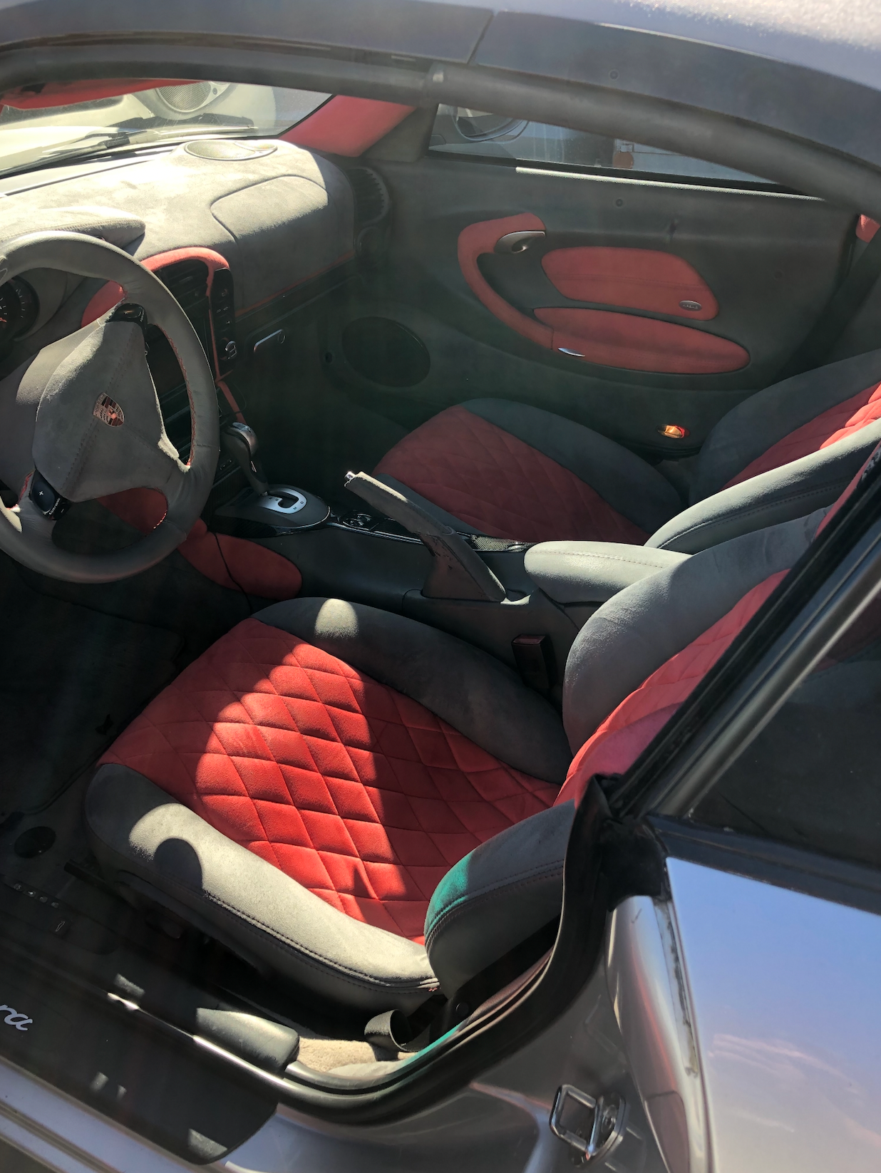 A silver car with red seats and a steering wheel