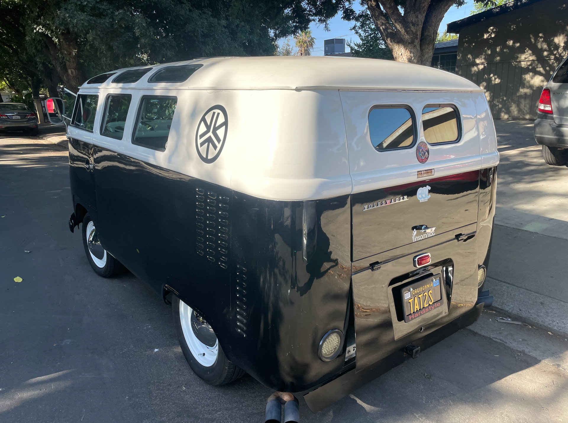 A black and white van is parked on the side of the road.