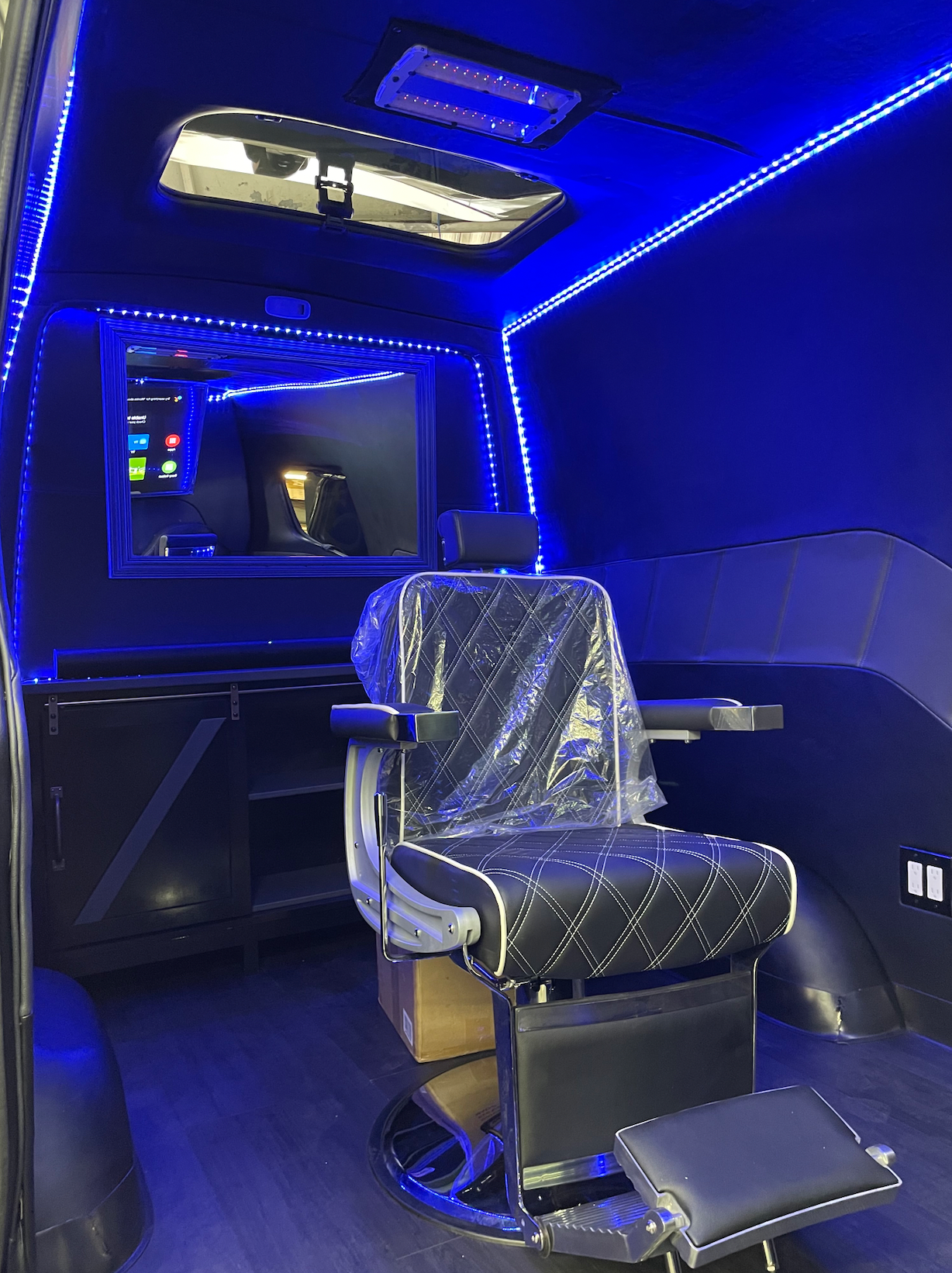 A barber chair is sitting inside of a van.