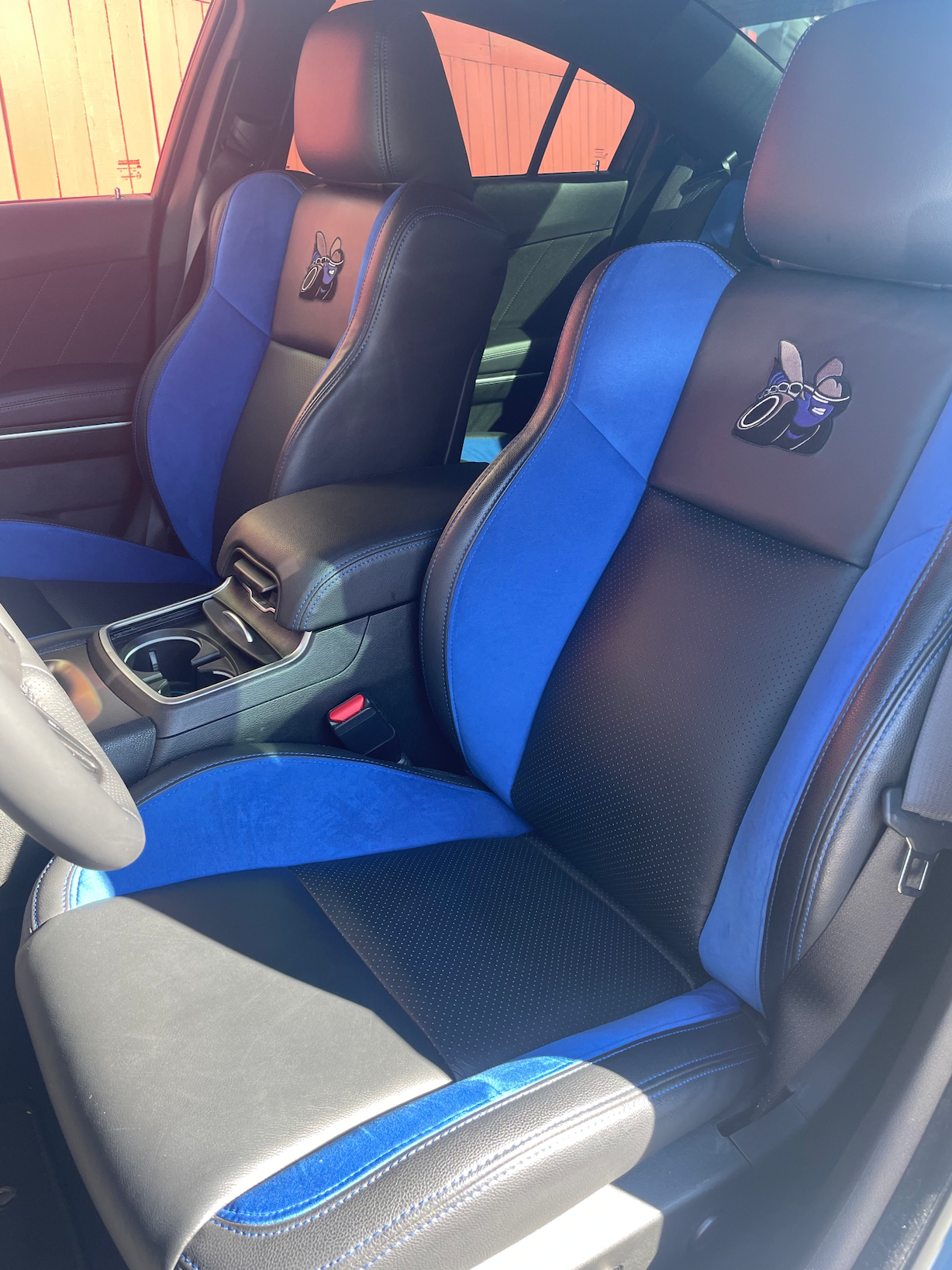 The front seats of a dodge charger are black and blue