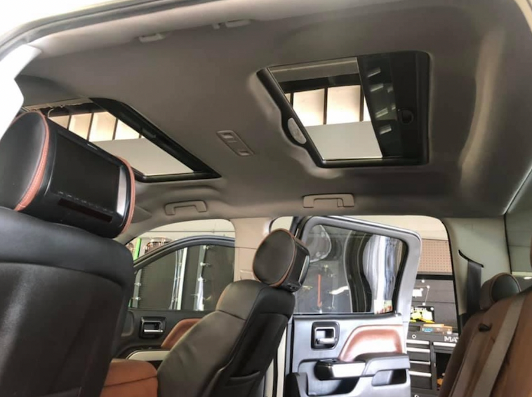 A car with a sunroof is parked in a garage.