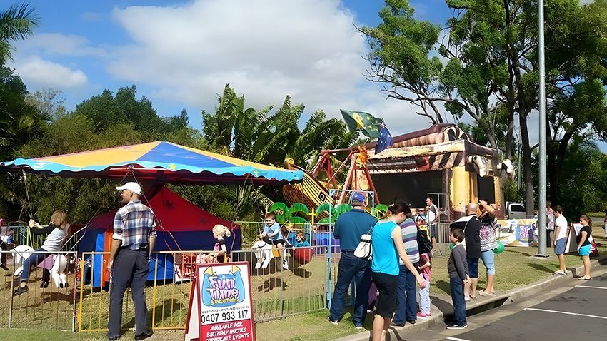 A Group of People Standing in Front of a Carnival Ride — Fun Time Amusements in Gracemere, QLD