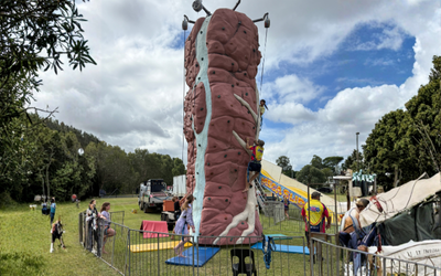 Rock Climbing Wall With Colourful Flags Against a Blue Sky — Fun Time Amusements in Gracemere, QLD