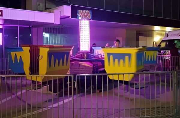 Carnival Ride With Spinning Yellow and Blue Cups Under Neon Lights — Fun Time Amusements in Gracemere, QLD