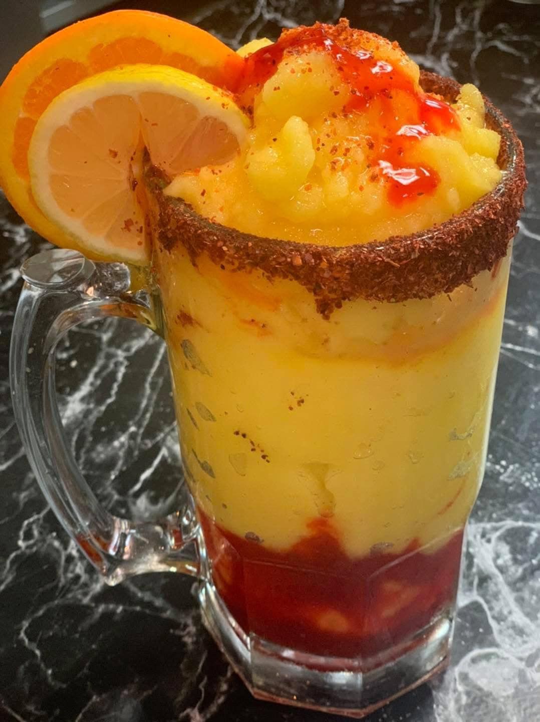 A drink in a mug with a slice of orange on top