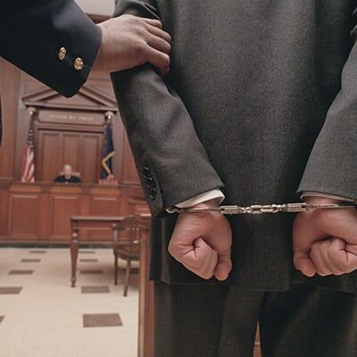 Businessman in handcuffs in courtroom — Law Firm in Columbus, IN