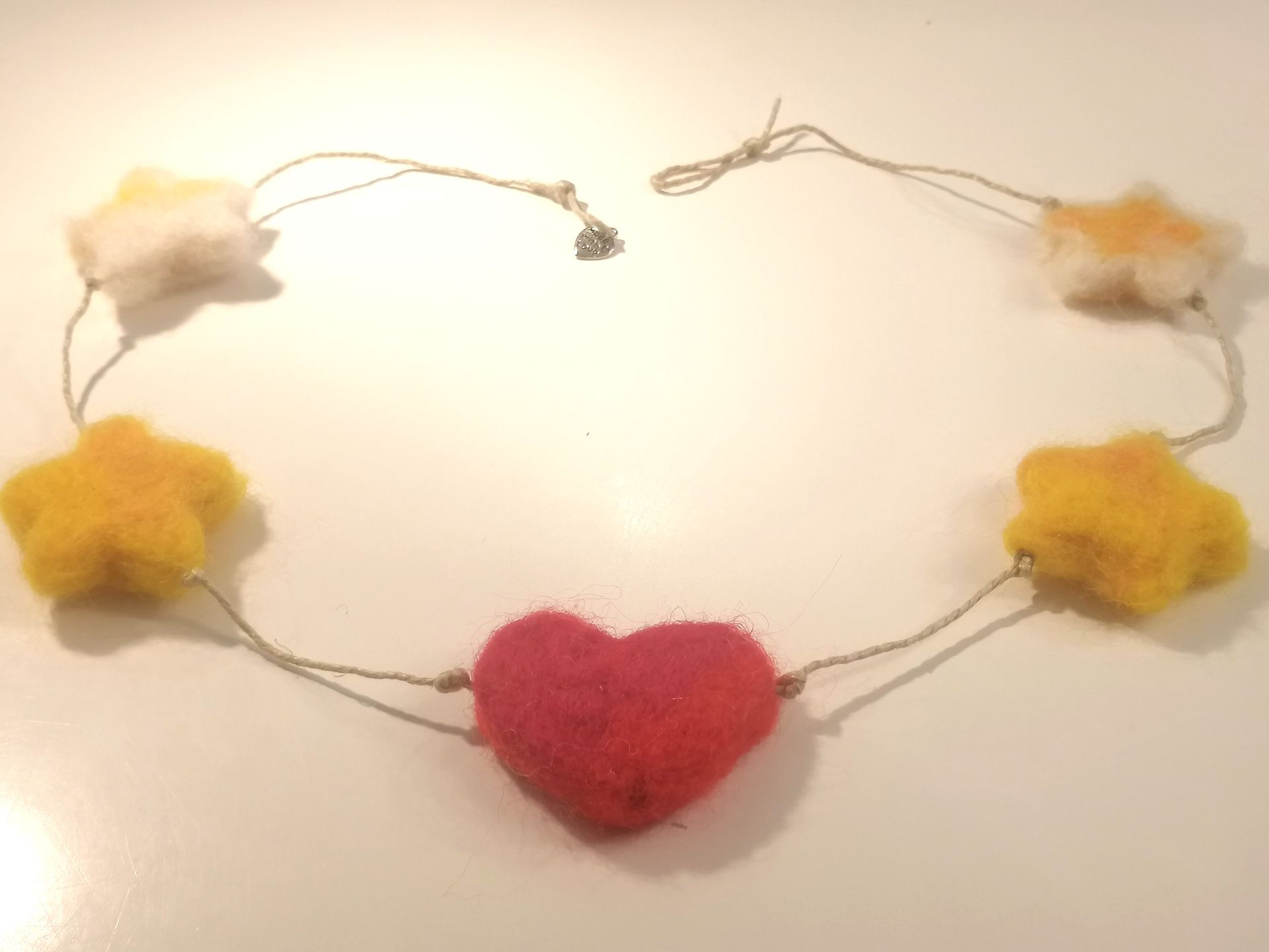 Rode vilten hartenslinger met parelkralen.