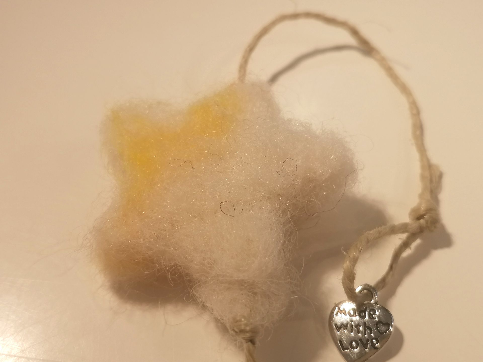 Hartenslinger van vilt in de kleuren rood, geel en kastanjebruin, met het opschrift