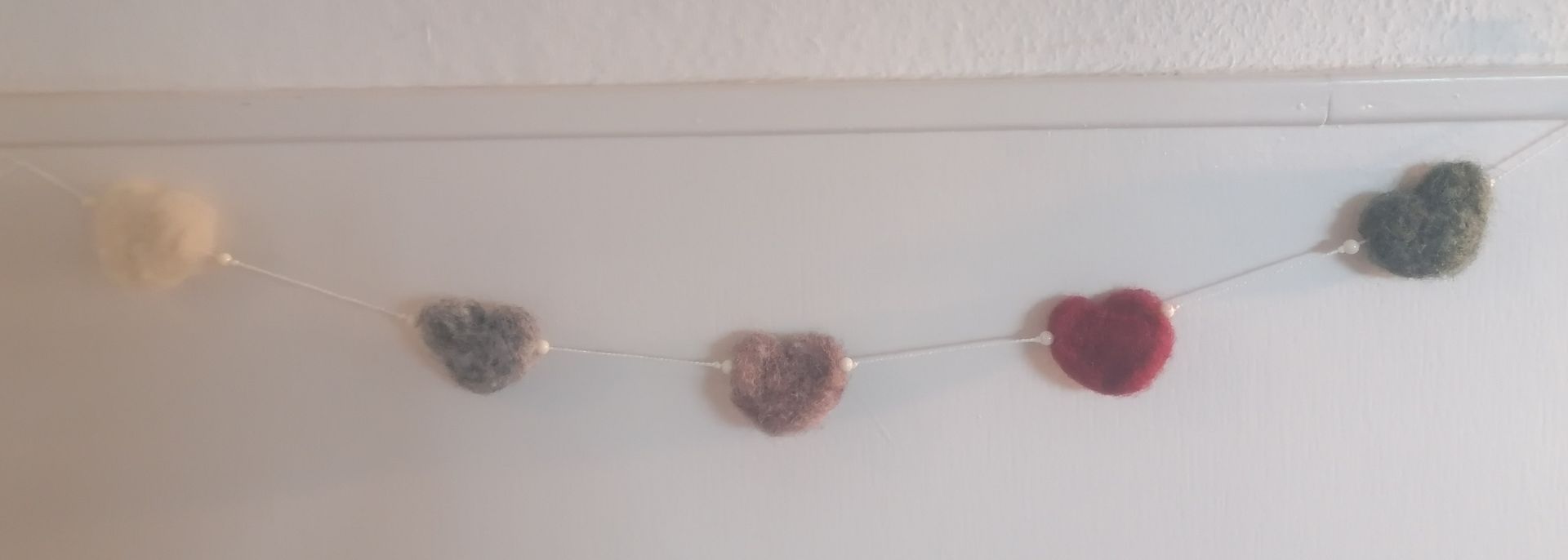 Een slinger met hartvormige versieringen in verschillende kleuren.