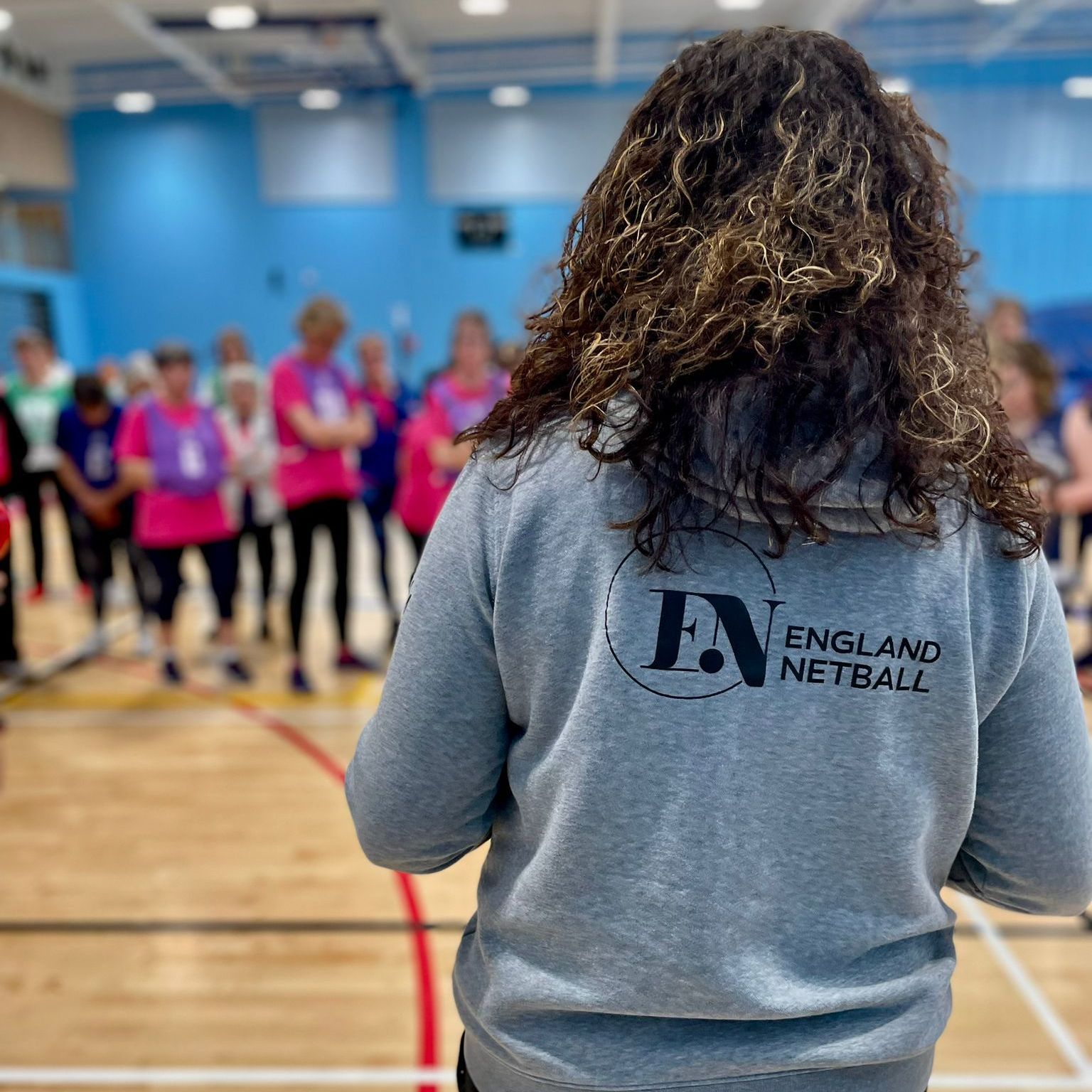 A woman wearing a grey england netball sweatshirt