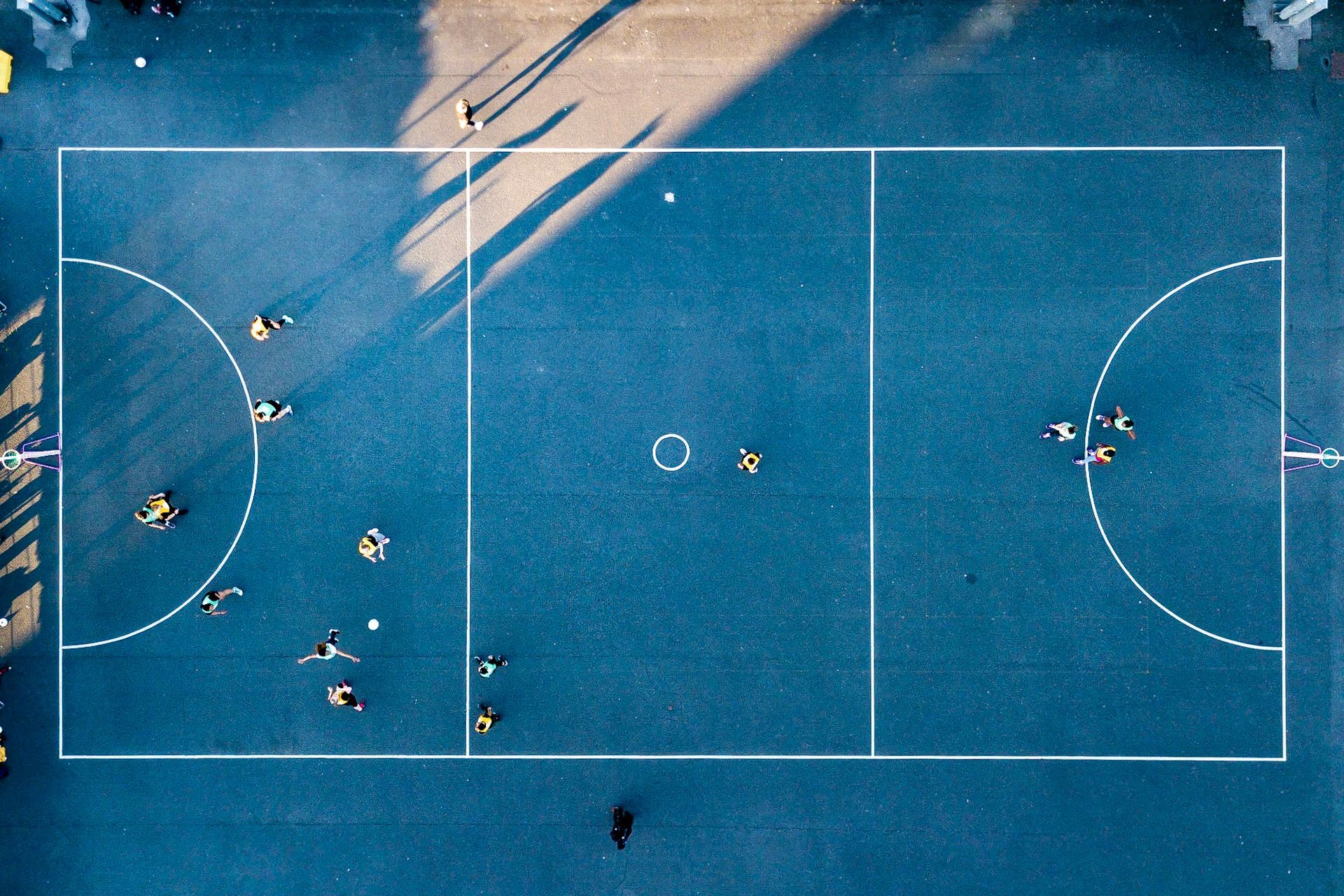 An aerial view of a basketball court with people playing on it.