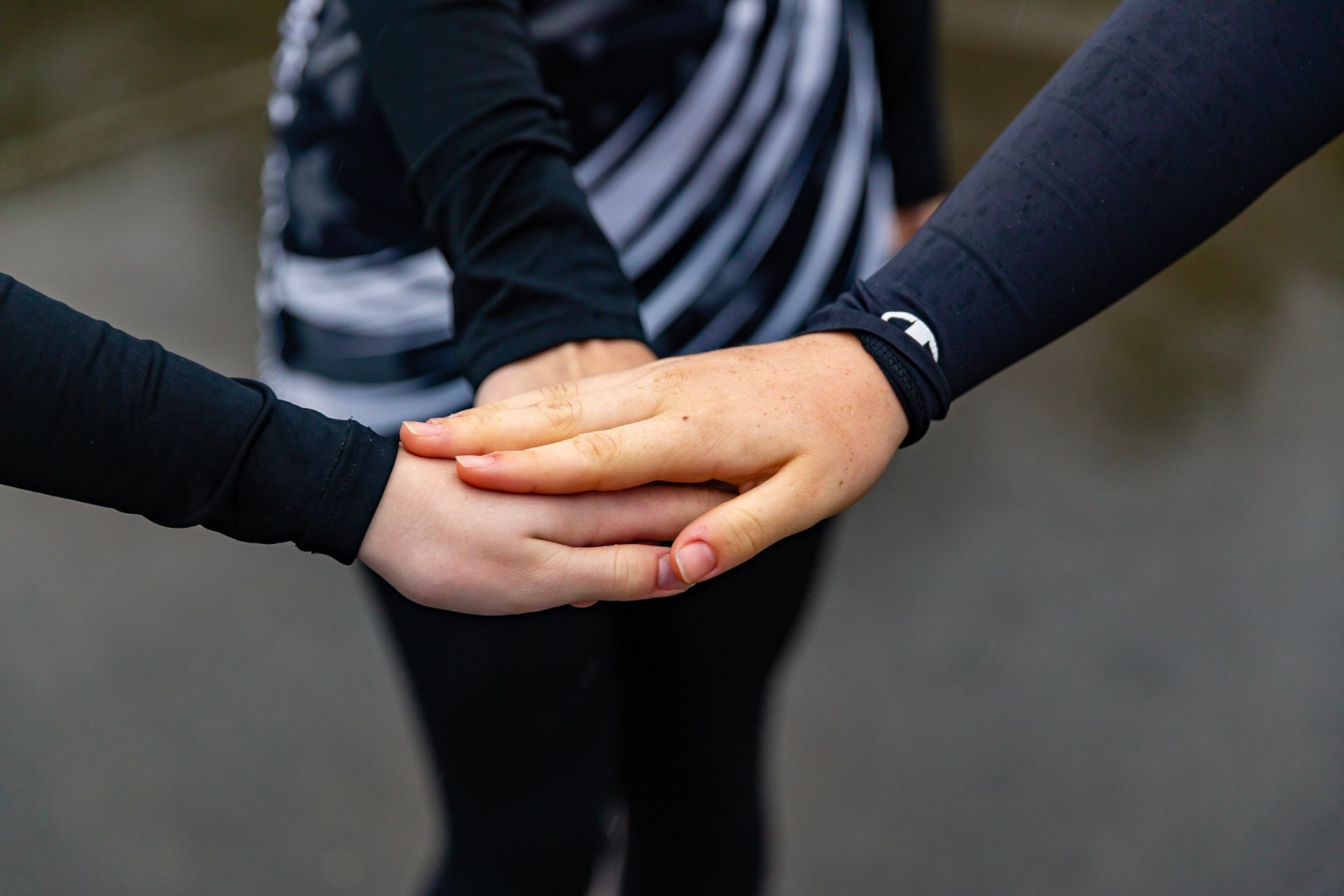 A group of people are putting their hands together.