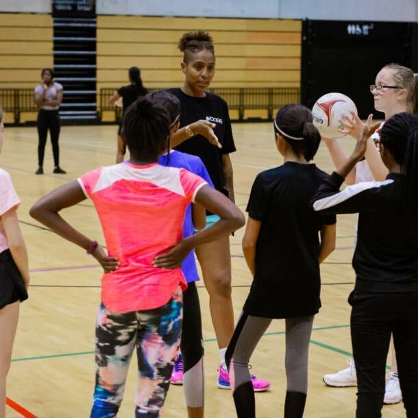 A group of young girls are standing on a basketball court