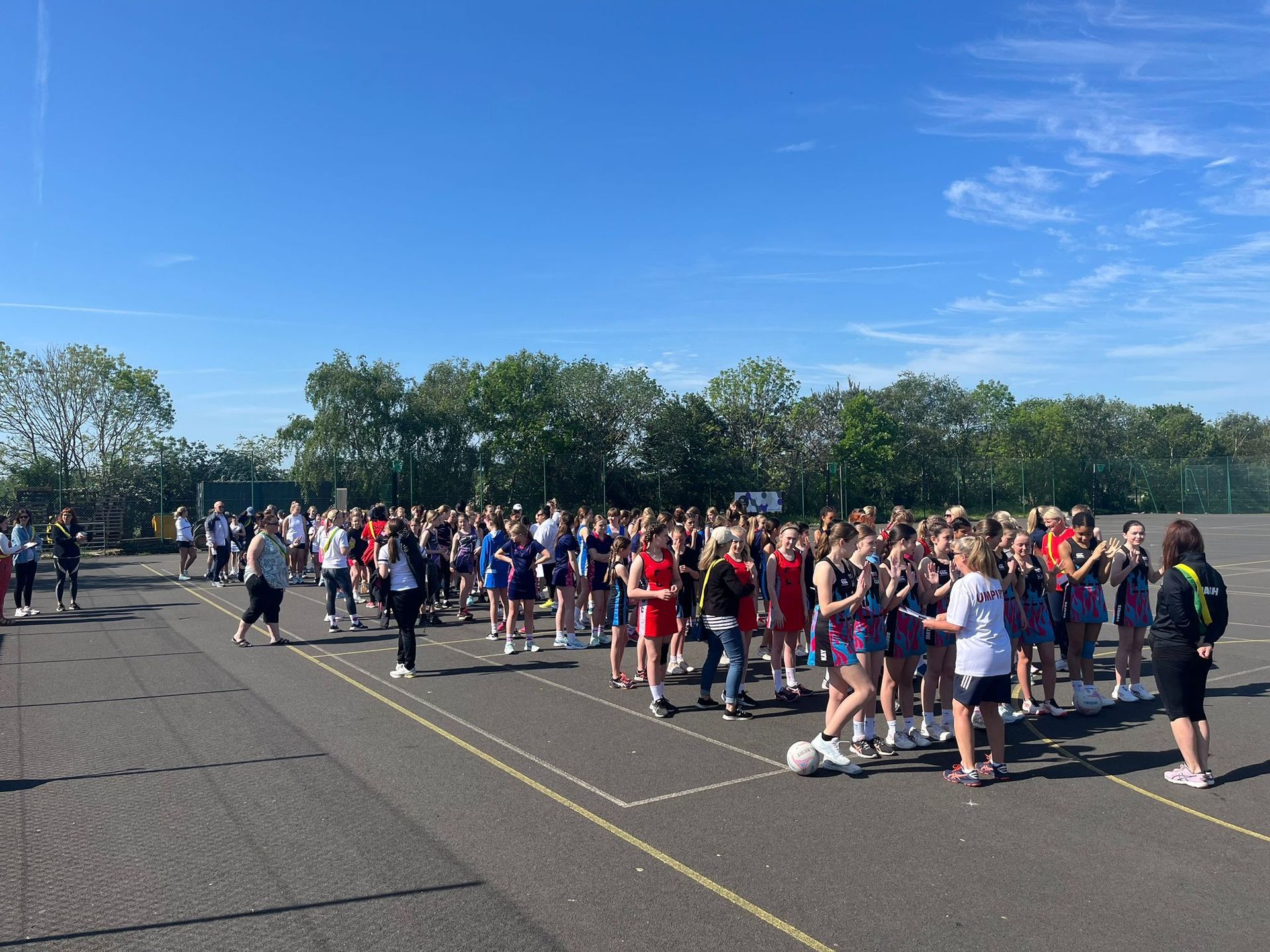 A large group of people are standing in a parking lot.