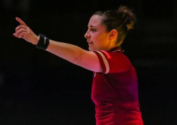 A woman in a red shirt is pointing at something