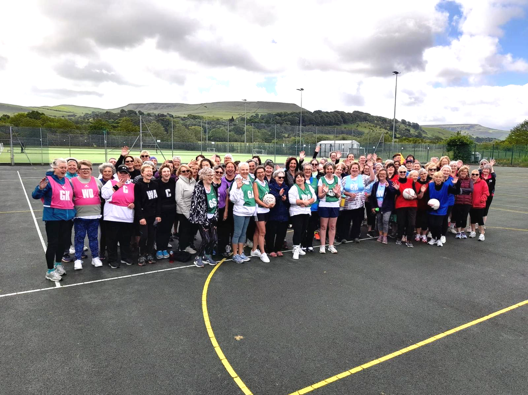 A large group of people are standing on a basketball court.